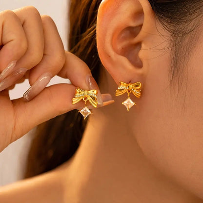 Pendientes lazo con circonita en acero titanio, bañado en oro de 18k - Madoma & Co.