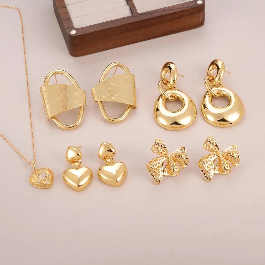 Pendientes de corazón y lazo acabado en oro de 18K, con incrustación de circonio, un diseño romántico y elegante. - Madoma & Co.